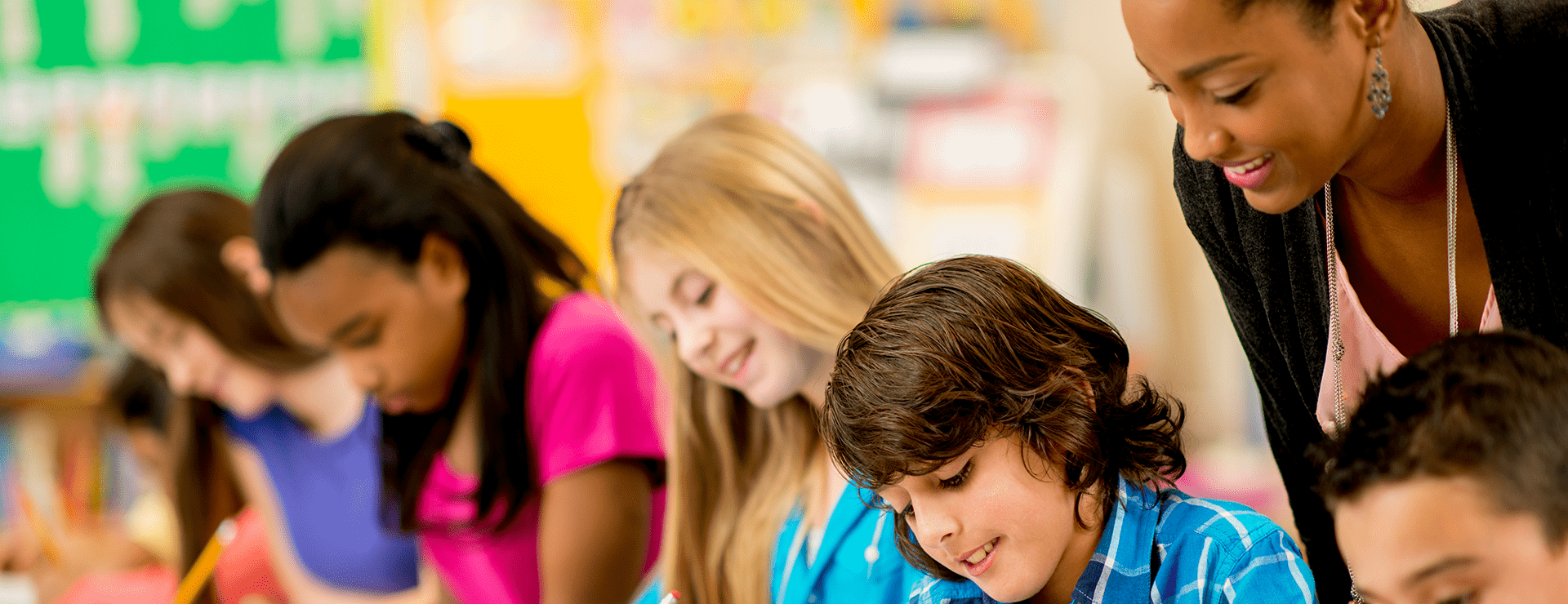 image of teacher helping a group of students